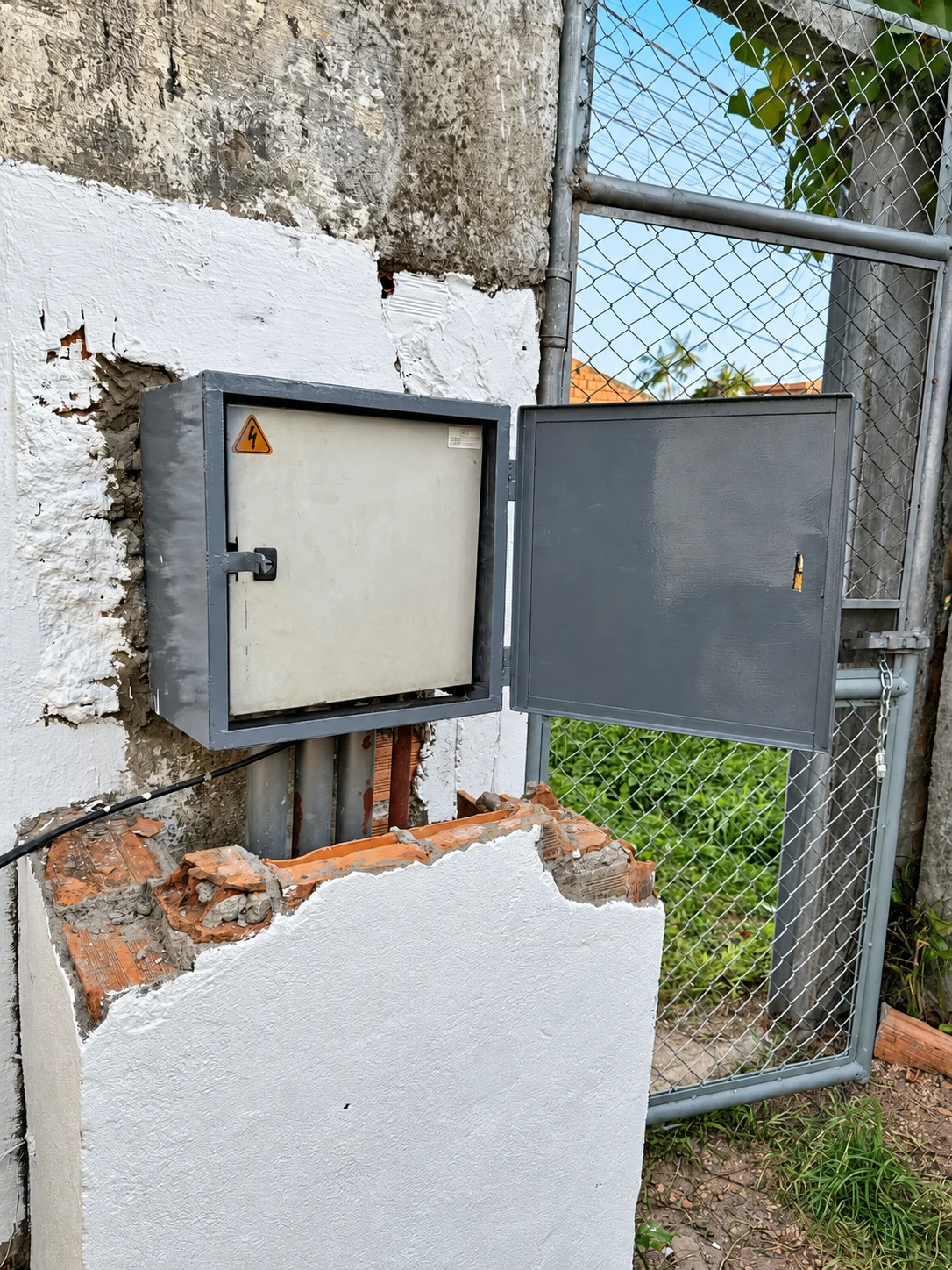 Vista do conjunto aberto, com a caixa externa e o quadro de energia em seu interior.